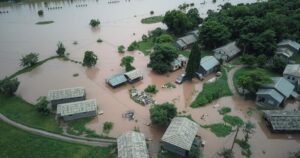 Rescue teams searching flooded. Aerial view of a flooded area with debris. Green vegetation and cloudy sky.