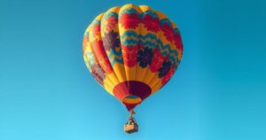 A serene hot air balloon flying in a clear blue sky, showcasing vibrant colors against a tranquil backdrop.