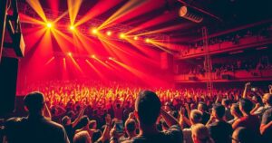 A vibrant concert scene with colorful lights illuminating a large venue packed with enthusiastic fans celebrating a musical event.