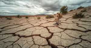 Dry landscape with cracked earth, sparse vegetation, and cloudy skies representing weather patterns in Africa.