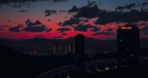 A dark skyline of uMlazi at twilight, hinting at mystery and intense events, with silhouettes of buildings and shadows.